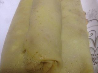 6、自制蛋卷,然后就开始卷了，卷的时候稍稍按压一下。像卷寿司那样。有条件的可以用寿司卷帘来卷。我是直接手卷的形状不是很好。