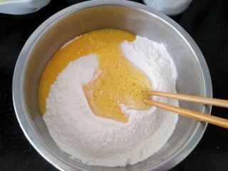 1、＃地方特色小吃＃  自制龙抄手,面粉中加入盐，鸡蛋打散倒入盆里，拌匀