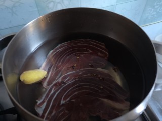 2、卤牛肉,锅内放凉水，花椒粒，姜片，加入牛肉煮开去血。
