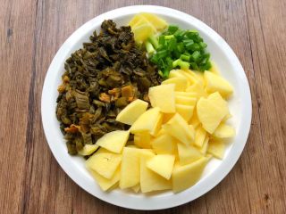 2、酸菜土豆烧春笋,土豆洗净切成薄片，酸菜洗净切碎，生姜去皮清洗干净切成片，葱洗净切葱段。