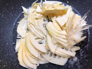 3、酸菜土豆烧春笋,竹笋削掉外皮，清洗干净切成薄片，放入锅里，倒入适量水，水量和食材齐平即可，大火把水煮开。