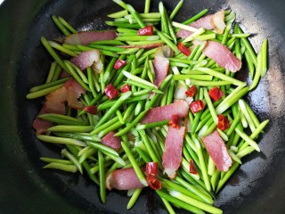 11、蒜苔炒腊肉,加入干辣椒。