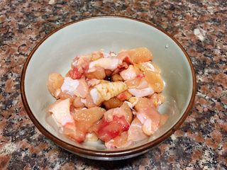 4、小煎鸡,将鸡肉切成小丁加入适量生抽、料酒拌匀腌制片刻。