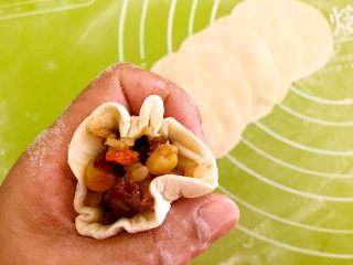 24、腊肠糯米烧麦,用手握起来，拇指和食指收紧，包成烧麦