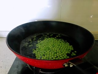 4、小炒腊肉丁,豌豆洗净，锅烧开水，豌豆焯水一分钟。如是冷冻豌豆，可提前放入清水中解冻。