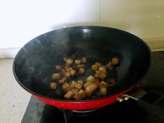 8、小炒腊肉丁,锅置于火上，放一点点油，下入腊肉，炒至出油。（腊肉丁中有肥肉，会有油出来）