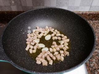 8、糖醋藕丁,放入大蒜片翻炒出香味。