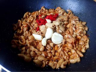 12、早餐+泡椒肥肠刀削面,接着放入泡椒、泡姜、蒜瓣翻炒出香味。