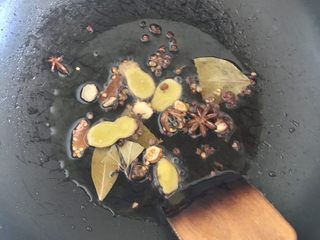 11、独家香辣鸡翅尖,油烧熟以后温度很高，为避免香料下锅后温度过高将香料炸糊，可以转小火或关火，然后把香料、生姜、冰糖放入锅中煸炒出香味