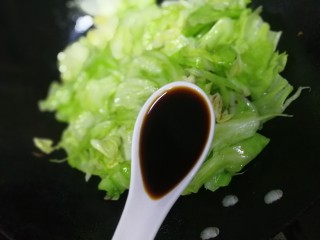 11、卷心菜炒粉丝,洒上一勺酱油炒匀。