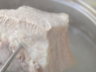 3、湖南梅干菜扣肉,肉放进锅加水加葱姜白酒煮,去腥味,煮到八成熟,捞出控干水分,码糖色上色