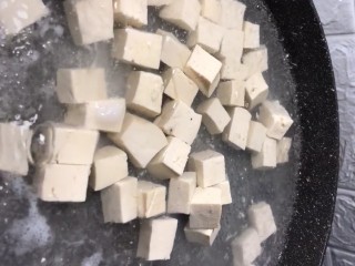 1、酸辣豆腐,准备一块豆腐切成小丁，水开下入豆腐，下入一勺盐