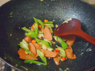 19、香肠炒蛋,倒入香肠和青椒大火翻炒3-4分钟