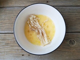 6、椒盐金针菇,将撒了椒盐的金针菇挂一层蛋液。