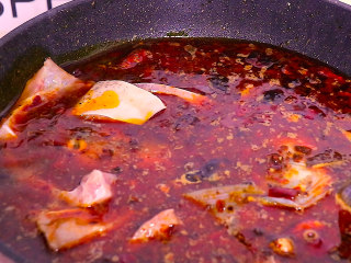 8、川妹子手把手教你做麻辣鲜香味美料足的水煮鱼,再放入鱼头和鱼骨煮3至四分钟左右