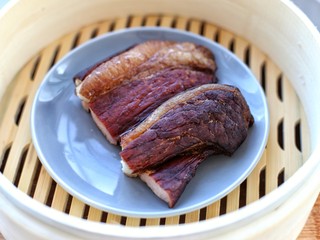 2、蒜苔炒腊肉,将腊肉放入水中开锅后煮约五分钟,捞出清洗干净放进蒸锅大火蒸十五分钟左右