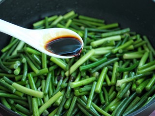 8、蒜苔炒腊肉,调入一汤匙生抽炒约1-2分钟