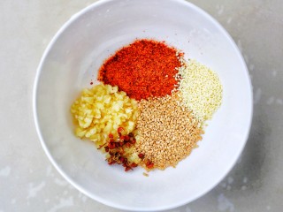 6、无敌下饭的香辣土豆片,准备调料碗，碗中加蒜末，辣椒面，白芝麻，五香粉，花椒粒，