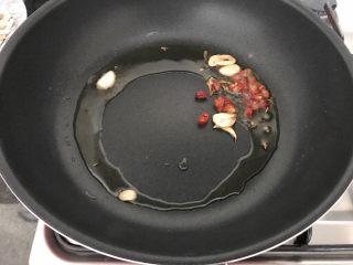 12、雪菜毛豆炒厚百叶,当油锅有7、8分热，开中小火将朝天椒和大蒜加进来