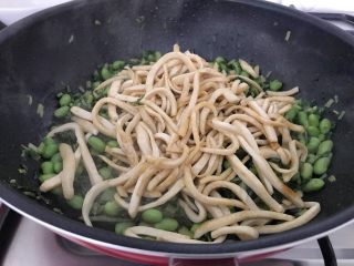 17、雪菜毛豆炒厚百叶,等毛豆和雪菜的水分煸炒接近收干时，毛豆和雪菜的鲜味也出来了，这时把厚百叶加进来，