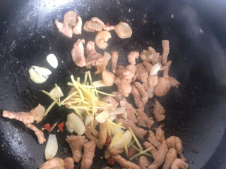 12、白玉菇炒肉,下入蒜片，姜丝干辣椒翻炒均匀
