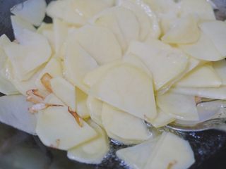 11、青椒香肠土豆片,葱头和蒜片出香味儿后倒入土豆，翻炒翻炒～