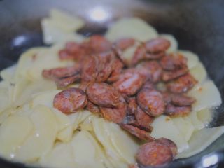 12、青椒香肠土豆片,土豆炒至8成熟（颜色变黄一些），倒入香肠片继续翻炒