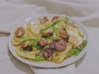 15、青椒香肠土豆片,再把盐翻炒进入食材里，土豆片变金黄黄啦～然后起锅，撒上葱末
