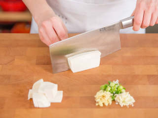 1、麻婆豆腐,将嫩豆腐切成均等的大小(长宽约2.5厘米),在盐水中浸泡约5分钟。将豆腐块拿出来,放在一旁备用。青葱切段,蒜切碎,洋葱和生姜切丁。