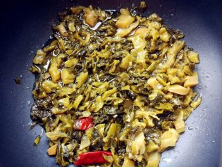 4、家常酸菜鱼,热锅热油，爆香姜片和蒜泥后，下野山椒和四川泡菜炒出香味。因为孩子吃不了太辣的，所以野山椒只放了一个