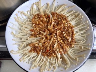 23、我爱蒜蓉系列➕蒜蓉粉丝金针菇,用工具????取出蒸好的金针菇,小心烫,揭去保鲜膜。蒸过的金针菇会出水,个头缩小,可以把它们用筷子整理一下