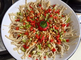 26、我爱蒜蓉系列➕蒜蓉粉丝金针菇,中间放上红椒小盖子装饰,撒上青红椒碎,粉丝金针菇都是白色的,我的大盘子也是白色(没有其他底色的大盘子里????)所以加上彩色的青红椒点缀一下
