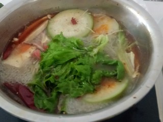 7、麻辣火锅,火锅煮开后，转中小火，放入白萝卜、豆腐，滚开后放入羊肉卷、牛肉卷、金针菇、生菜。