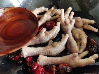 8、香辣卤鸡爪,倒入一勺料酒翻炒去腥。