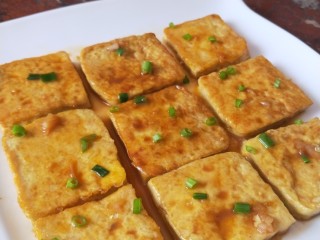 11、锅塌豆腐,盛盘，把汤汁浇在表面，撒葱花点缀。