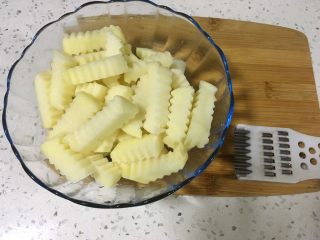 2、狼牙土豆,用类似图中的模具将土豆切成厚度为1厘米左右的狼牙形状。切好之后把土豆用水浸泡一下。