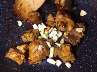 6、糖醋排骨,将大蒜去皮洗净切丁放入翻炒