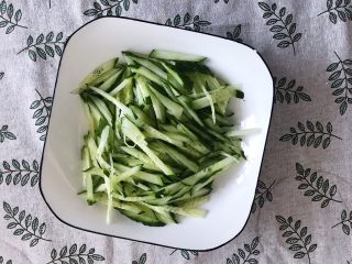 12、家庭版凉拌口水鸡,将黄瓜丝平铺碗底