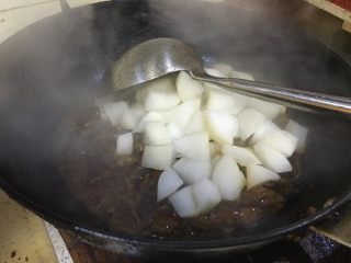 13、牛腩白萝卜火锅,加入压好的白萝卜。翻炒