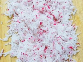 5、炸萝卜丸子,把大萝卜丝放在菜板上，用刀切不要太碎