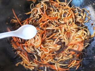 14、鱼香杏鲍菇,加入适量的盐，鸡精，继续中火翻炒。