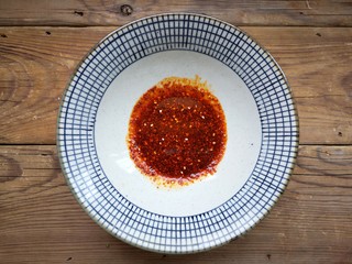 11、重庆红油抄手,碗中加入秘制红油辣椒、花椒粉、鸡精、盐、香醋、味极鲜酱油调匀。