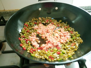 11、红油泡豇豆炒肉末,加入肉末，快递翻炒均匀后加入5克味精翻炒均匀即可出锅。