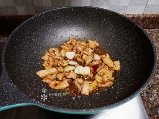 10、韭菜炒豆腐,放入大蒜片翻炒均匀。