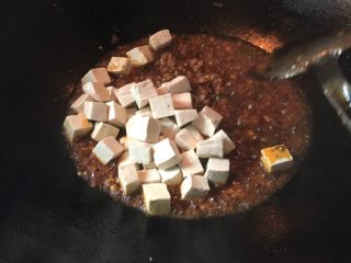 3、麻婆豆腐,炒均匀了后加入海椒面，可以根据你的颜色来看加多少辣椒面，颜色淡可以多加点，炒散后倒入豆腐，再加点少量的水，最后调味加入适量的盐，味精，鸡精，最后沟点淀粉，起锅撒上花椒面，葱花，就完成了