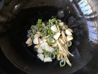 5、辣炒小鱼干,锅中适量油烧热,下入葱姜蒜爆出香味。