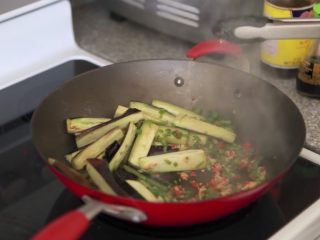 8、快速简单，鱼香茄子,把茄子拨到一边，再加点油，把葱姜蒜末和辣椒碎一起倒入翻炒至闻到香味