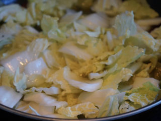 10、酸菜肥牛,大火将水烧开，放入白菜叶。