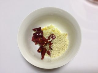 8、凉拌干丝金针菇,将蒜瓣切成蒜末（不用很细），辣椒切段去籽（喜欢很辣的就多加辣椒，或者直接加入油泼辣子也OK），芝麻全部放入一个小碗里