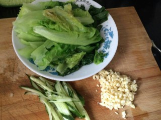 1、素食拌面,先把蒜切成末，黄瓜切成条，将生菜过水，摆好。
